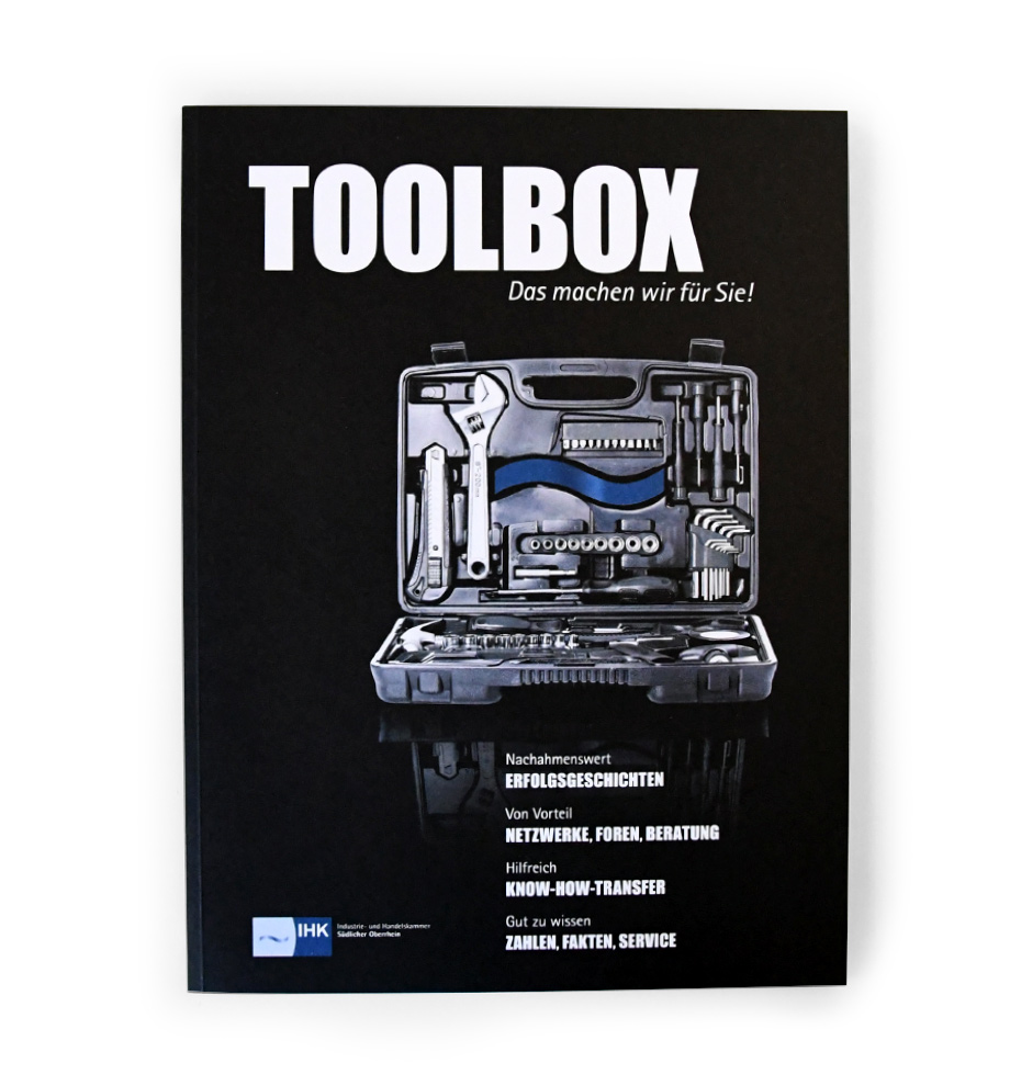 IHK Magazin TOOLBOX - Cover: Offener Werkzeugkasten mit Werkzeugen und der Welle des IHK-Logos.