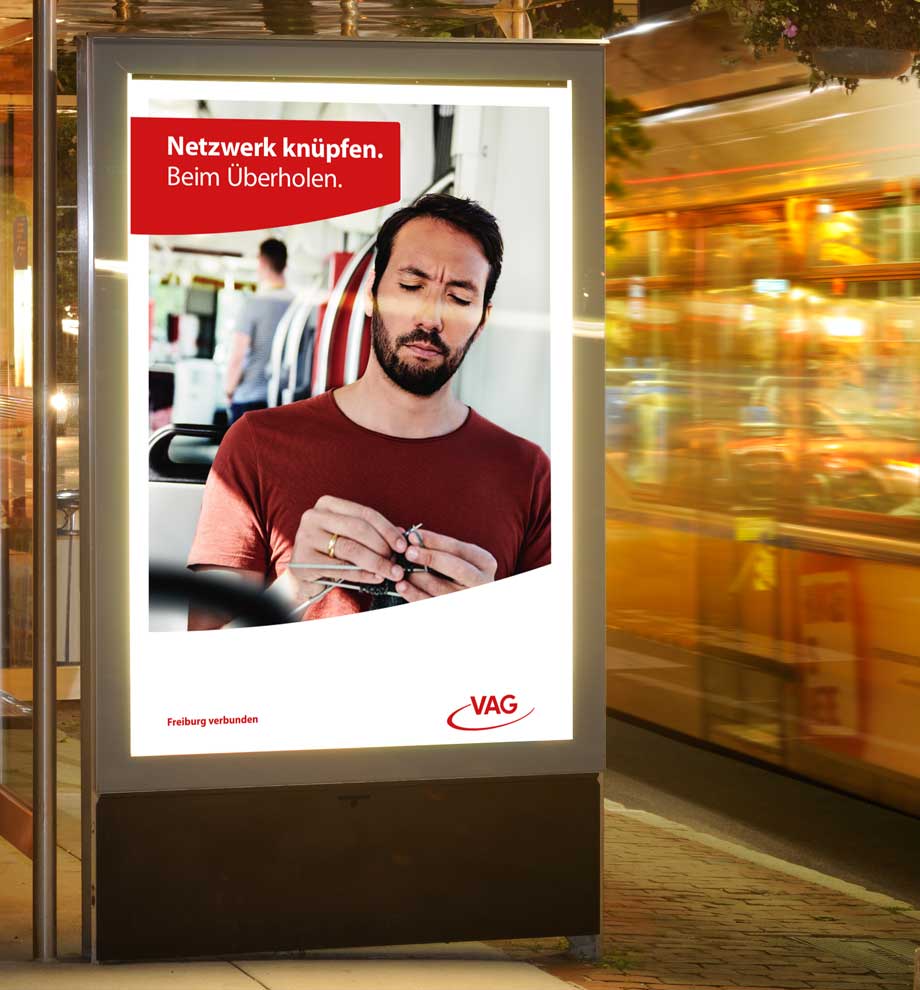 VAG Freiburg Werbung von Werbeagentur Schleiner und Partner - Mann strickt in der Strassenbahn - Der Titel lautet Netzwerk knüpfen. Beim Überholen.